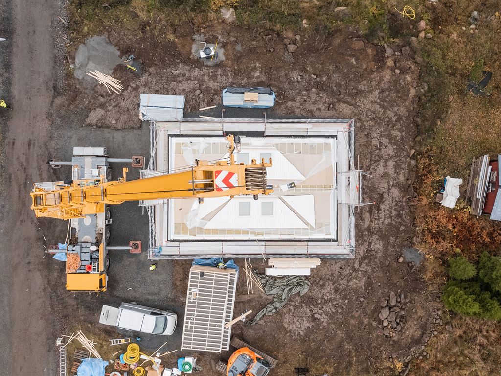 En hustillverkare monterar en villa på byggplats