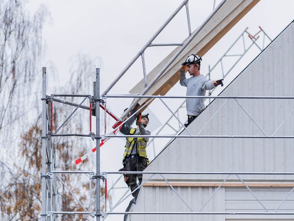 Byggarbetare för hus fixar med tak