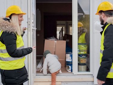Familj med barn besöker hus som de håller på att bygga för första gången
