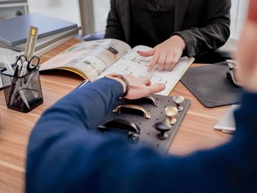 Hand på man som ska skriva på kontrakt för att bygga nytt hus