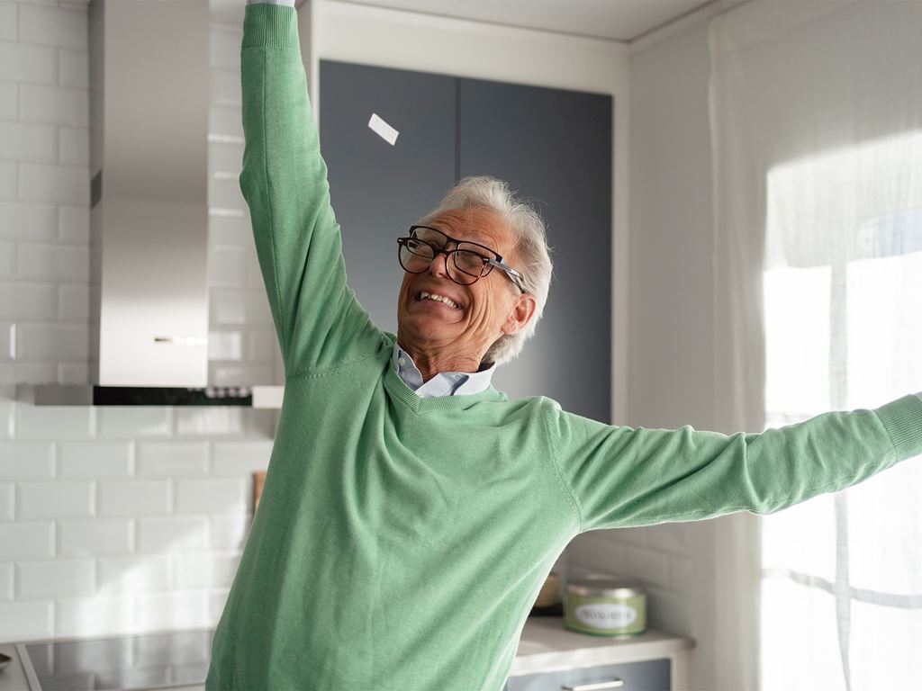 Äldre man firar låg elräkning i nybyggt hus