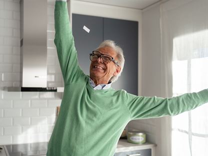 Äldre man firar låg elräkning i nybyggt hus