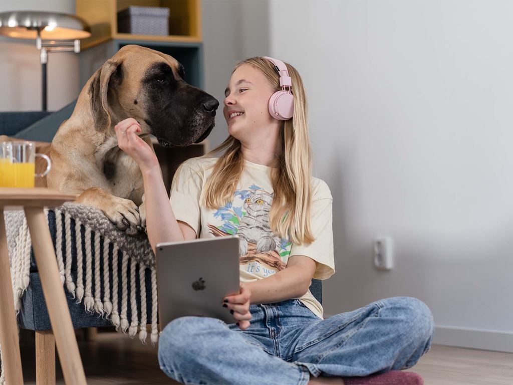 Tonåring och hund myser i vardagsrum