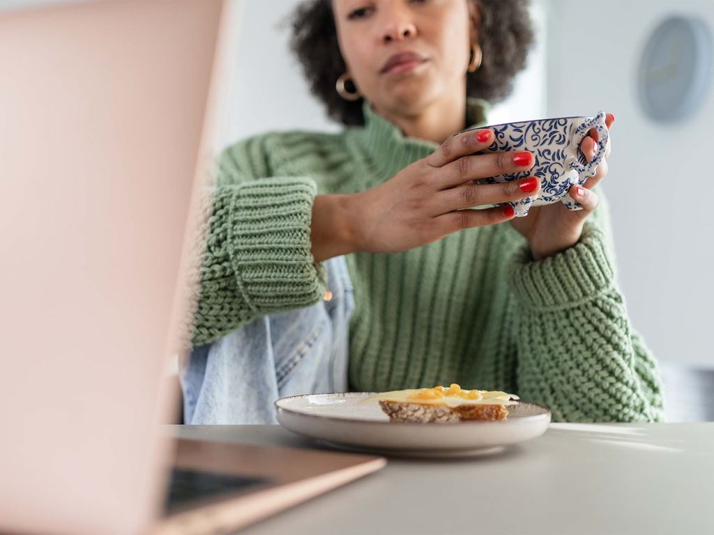 Kvinna funderar på att stycka av tomr när hon äter frukost