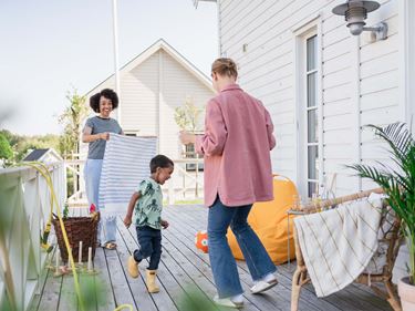 familj umgås på altan till nybyggt hus