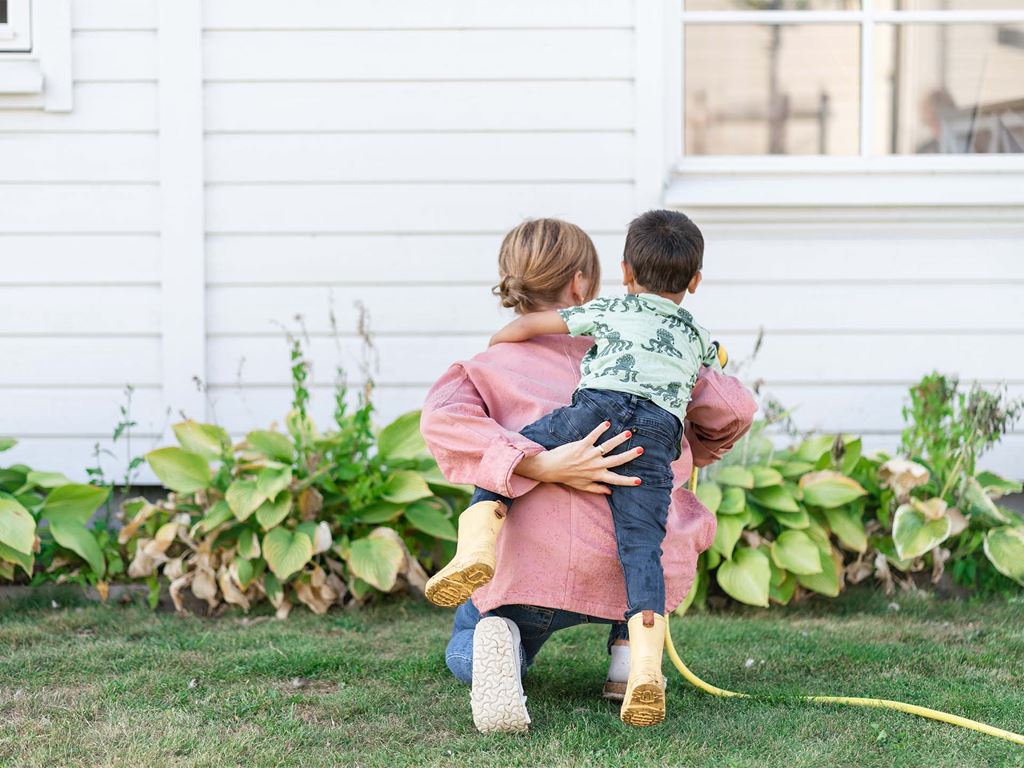Mamma visar son deras nybyggda hus