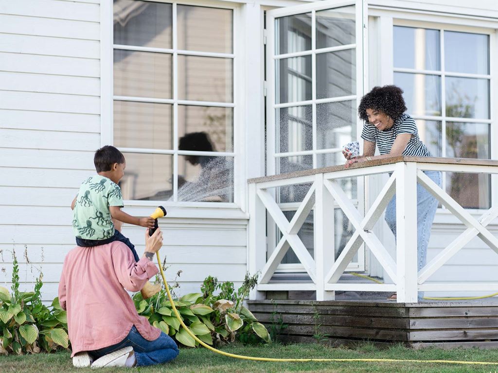 Familj på uteplats utanför sitt nybyggda hus