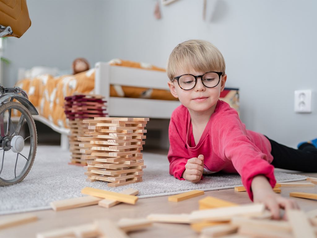 Pojke bygger ett hus av klossar