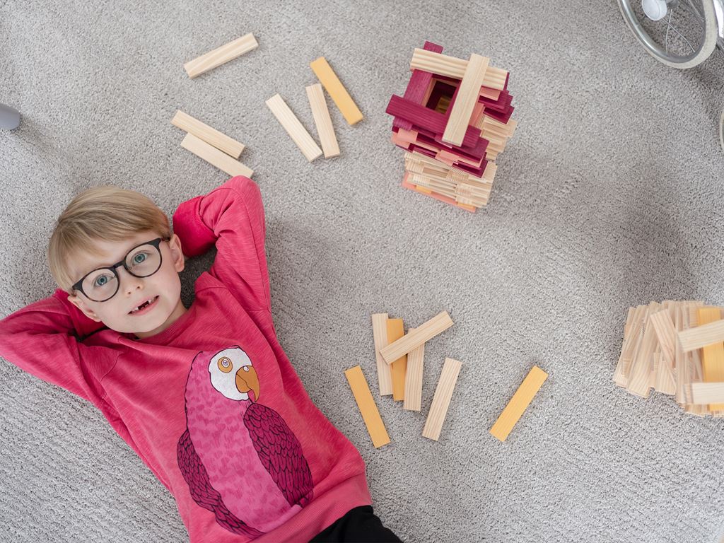 Pojke ligger och vilar sig efter att ha byggt klossar