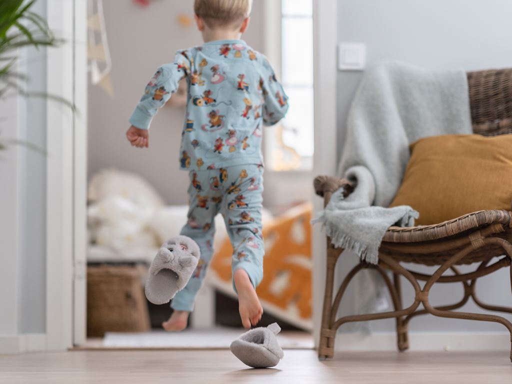 Pojke springer genom nybyggt hus i pyjamas