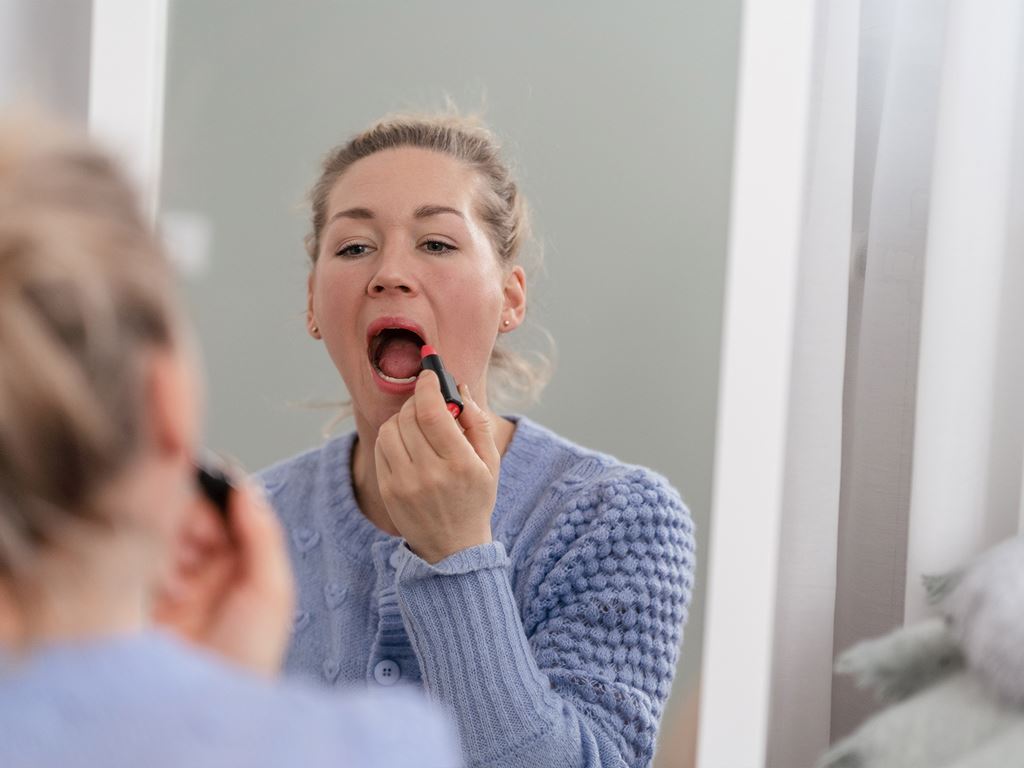 Kvinna sminkar sig i nybyggt hus