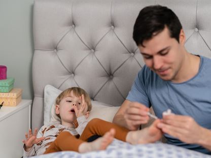 Pappa målar pojkes naglar i sängen