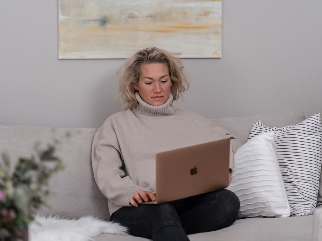 Kvinna i soffa med laptop lär sig hur man bygger hus