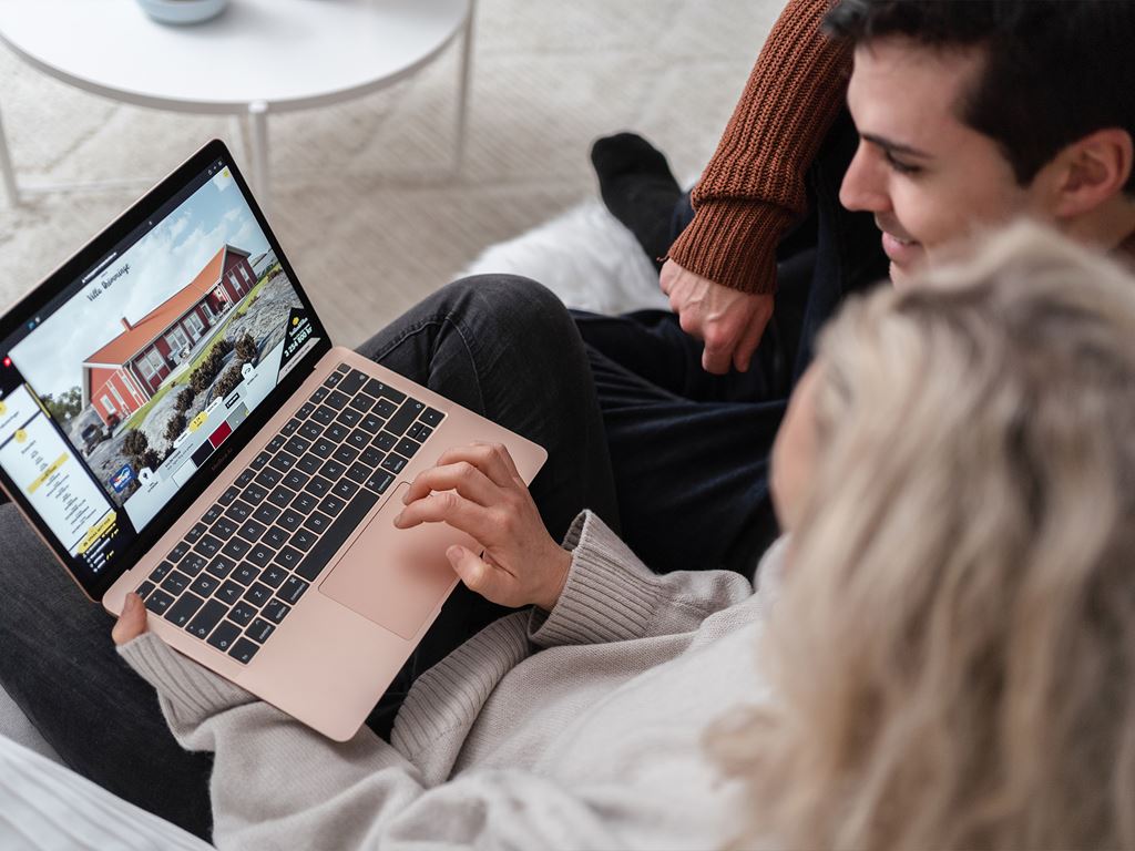 Ungt par med laptop.utvärderar husleverantör