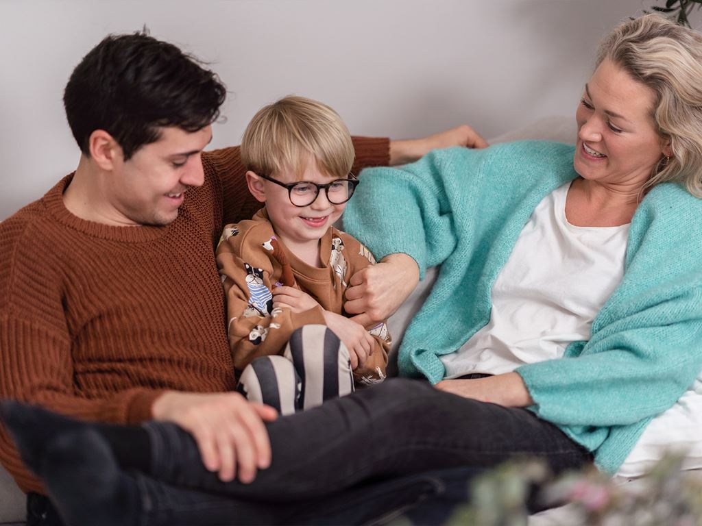 Föräldrar leker med barn i vardagsrum