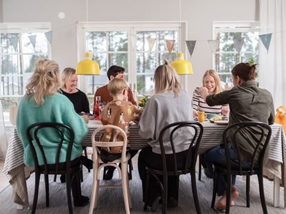 Stor familj äter middag i enplanshus
